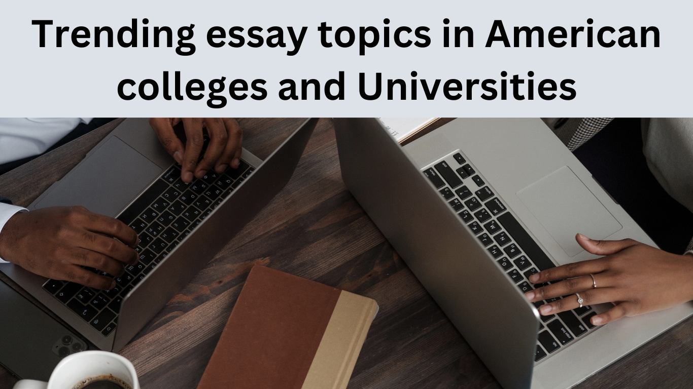 Two people are working on laptops at a wooden table, accompanied by a closed notebook and coffee cup. Text above reads, Trending essay topics in American colleges and universities—discover whats shaping academic conversations today.